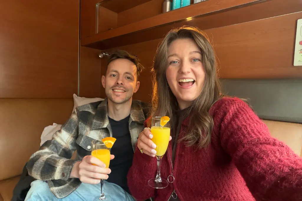 Chelsea and James have drinks in the Prestige cabin on The Canadian