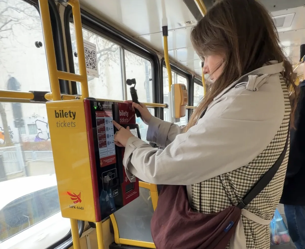 Chelsea using a ticket machine on a tram in Lodz